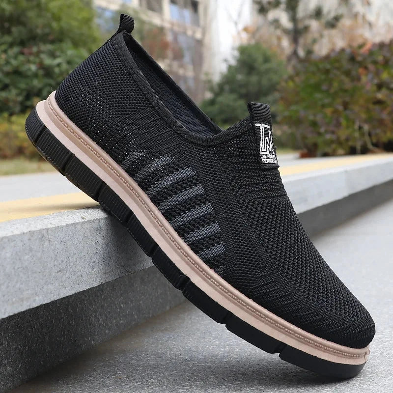 Casual men's shoes featuring a stylish knit upper in a light gray color, detailed view showcasing the texture and design elements