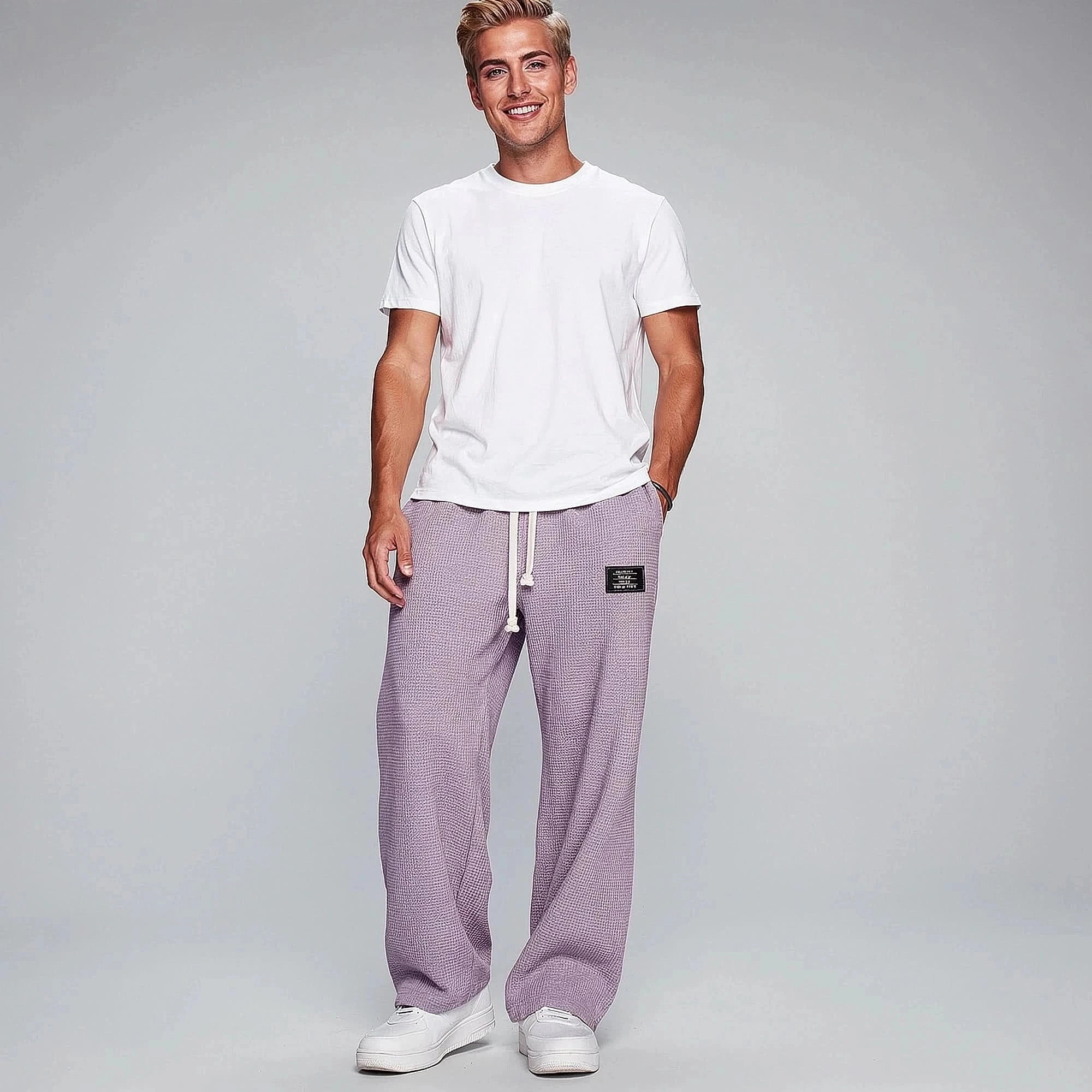 View of relaxed fit pants in soft beige fabric, featuring an elastic waistband and pockets