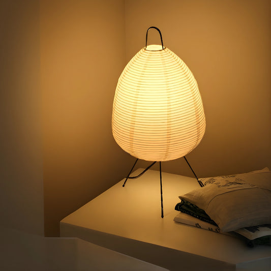 View of a serene minimalist rice paper table lamp in soft white, featuring a simple cylindrical shape and wooden base