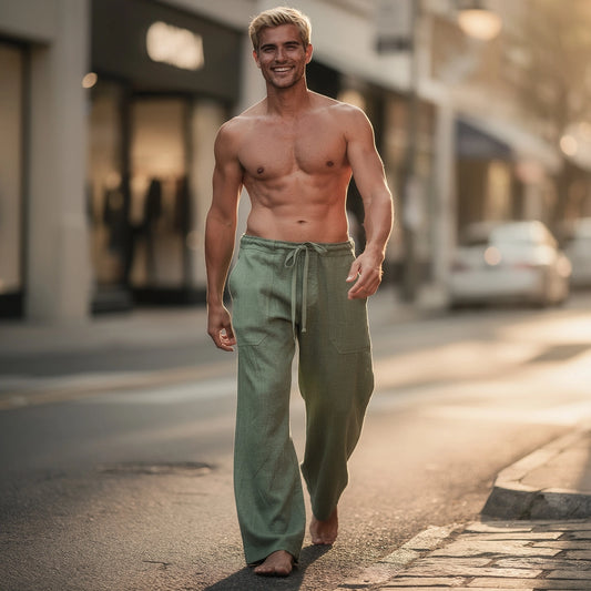 View of wide loose relaxed fit trousers in light gray fabric, featuring an elastic waistband and pockets
