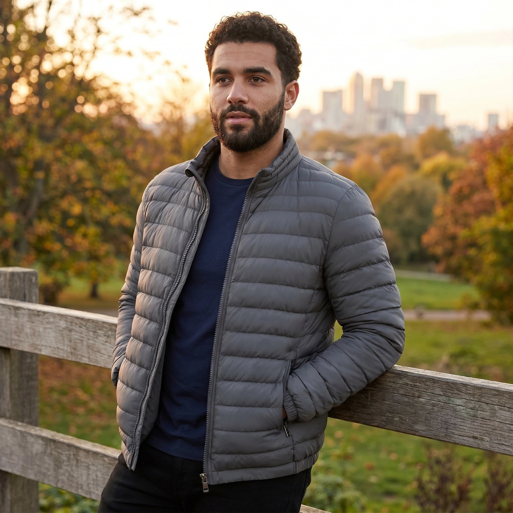 Back view of the men's lightweight slim transitional puffer jacket in navy, showing its sleek design and construction details against a neutral backdrop.