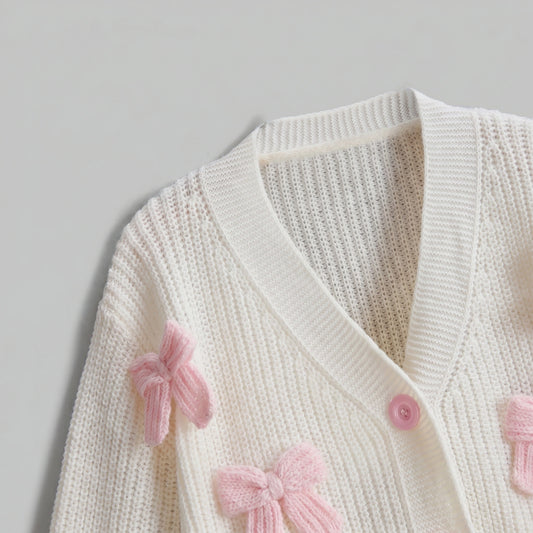 Back view of the Womens Whimsical Cozy Spring Cardigan in soft pastel colors, showing its intricate stitching and relaxed fit against a light, neutral background.
