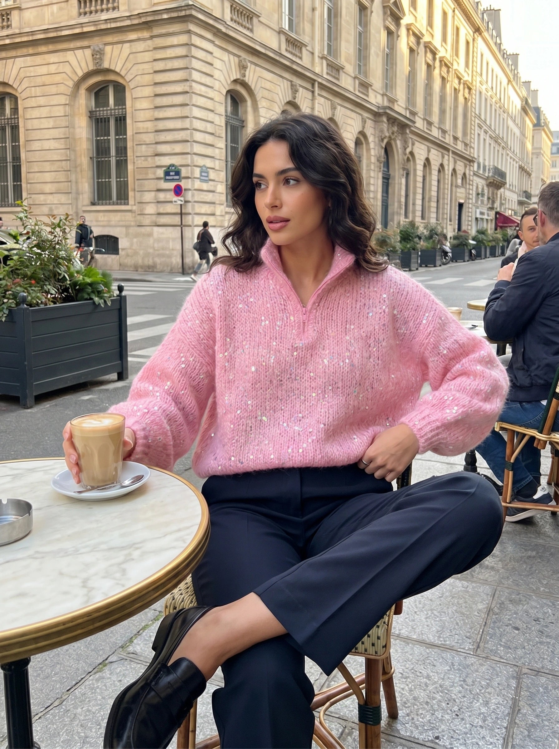 Back view of a model wearing a women's shiny sweater in a soft pastel color, showing the intricate knit construction and design.