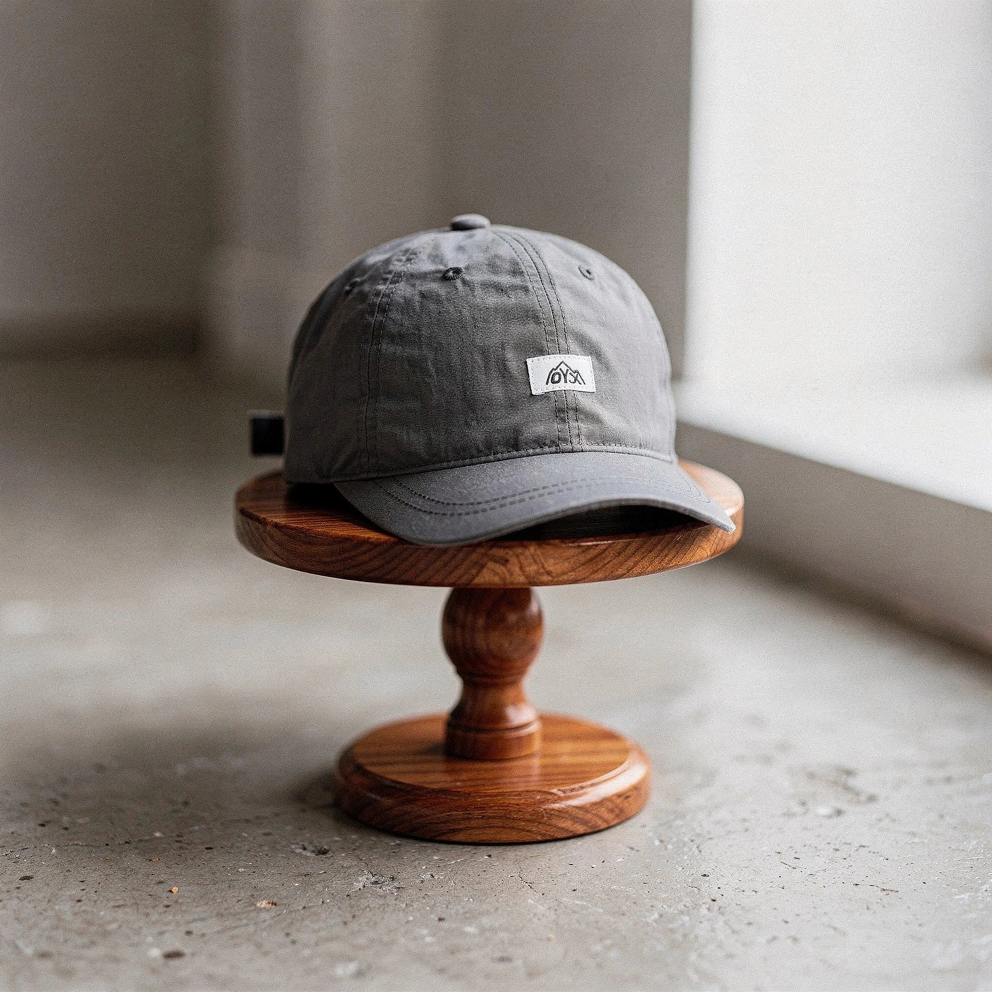 View of a stylish men's baseball cap in dark gray, made from breathable fabric, featuring a curved brim and adjustable strap