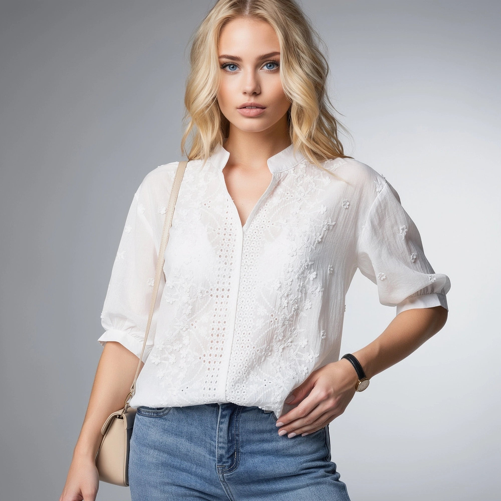 View of a light beige blouse featuring a V neckline, puff sleeves, and delicate fabric texture