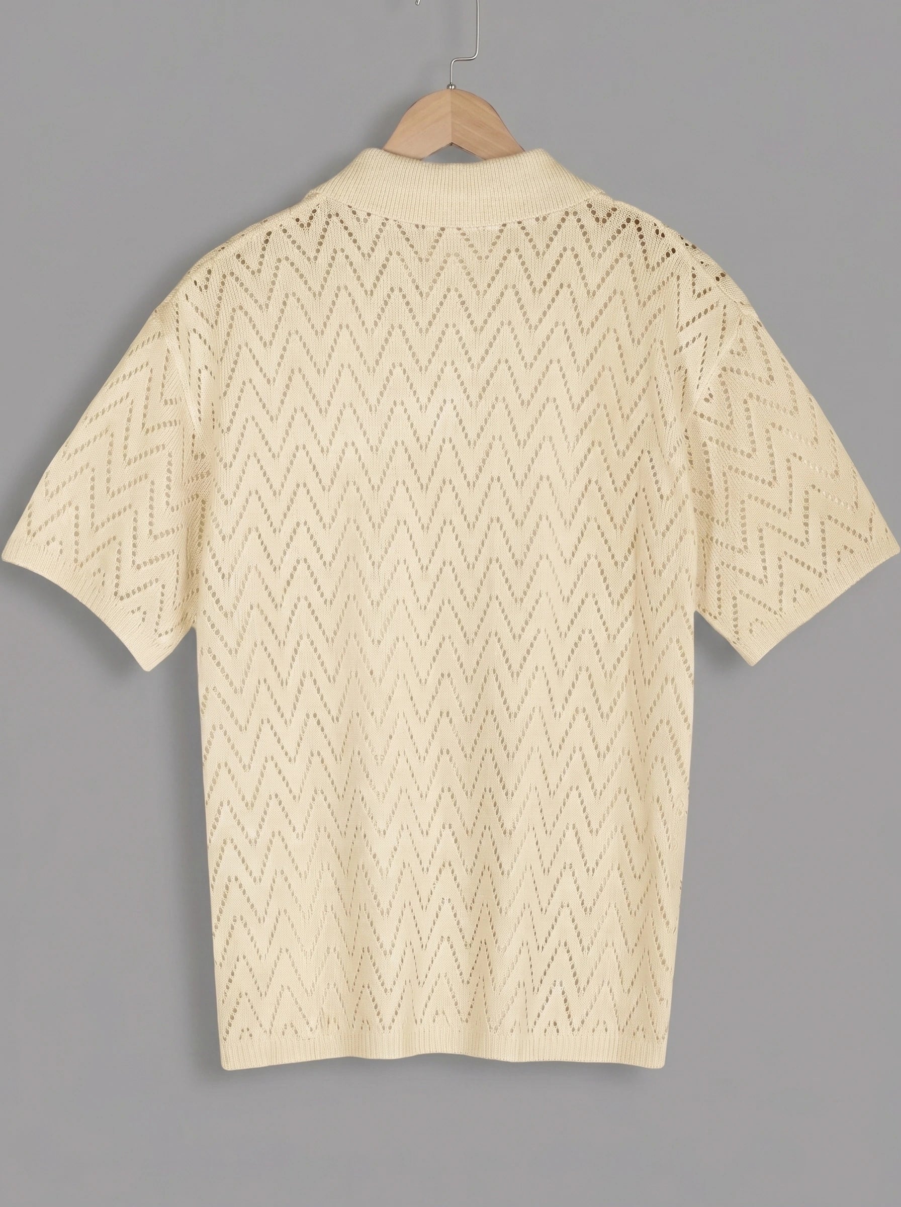 Close up view of the men's relaxed summer knit shirt showing its soft fabric texture and detailed stitching against a neutral background.