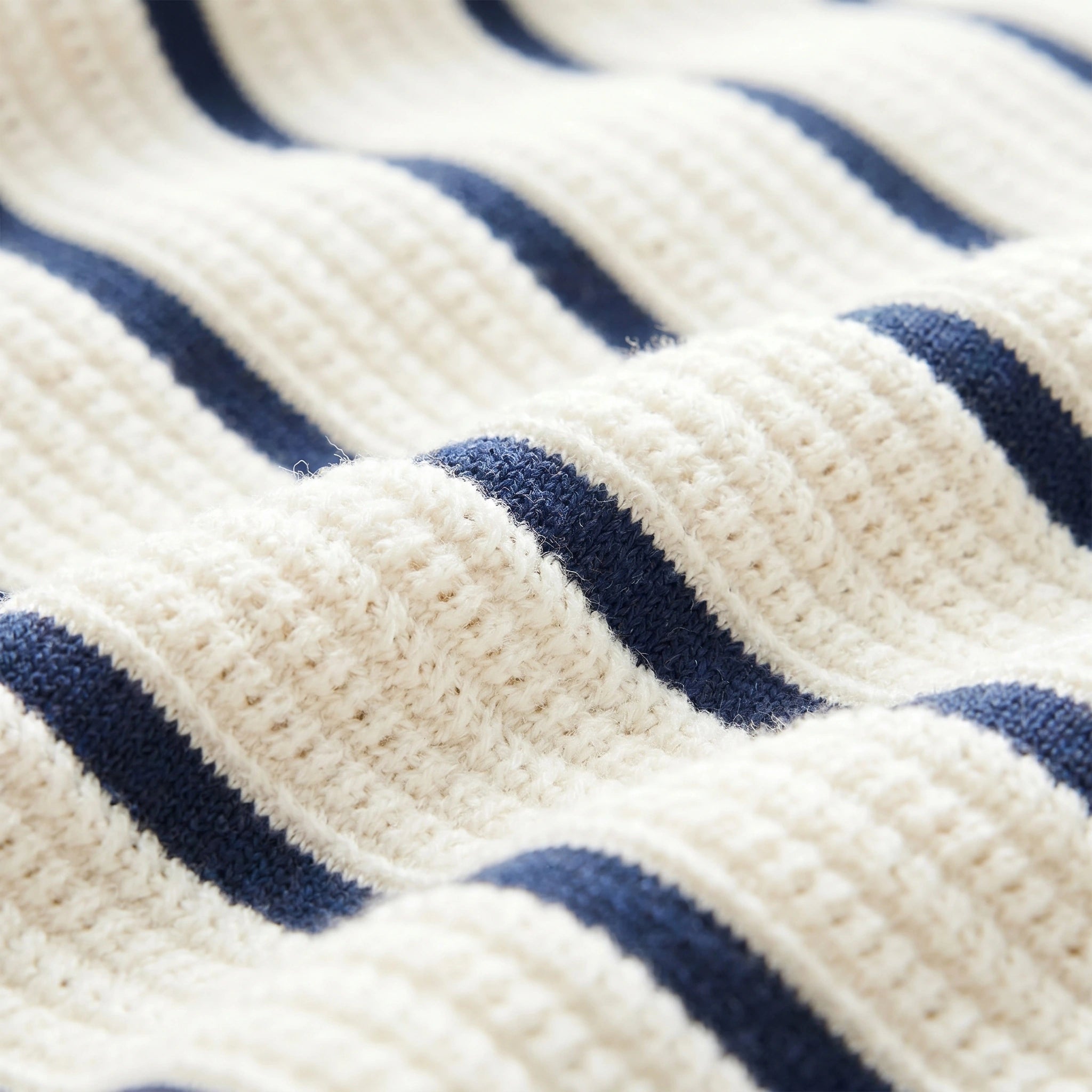 Close up view of the mens slim summer knit shirt showing its fine fabric texture and precise stitching, emphasizing its casual sophistication against a neutral background.