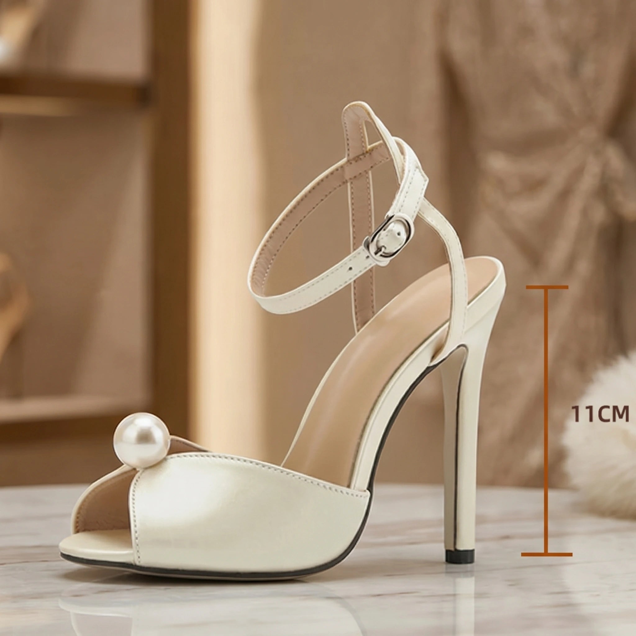 Close up of pearl embellished satin heeled sandals showing luxurious fabric texture and intricate stitching against a soft neutral background.