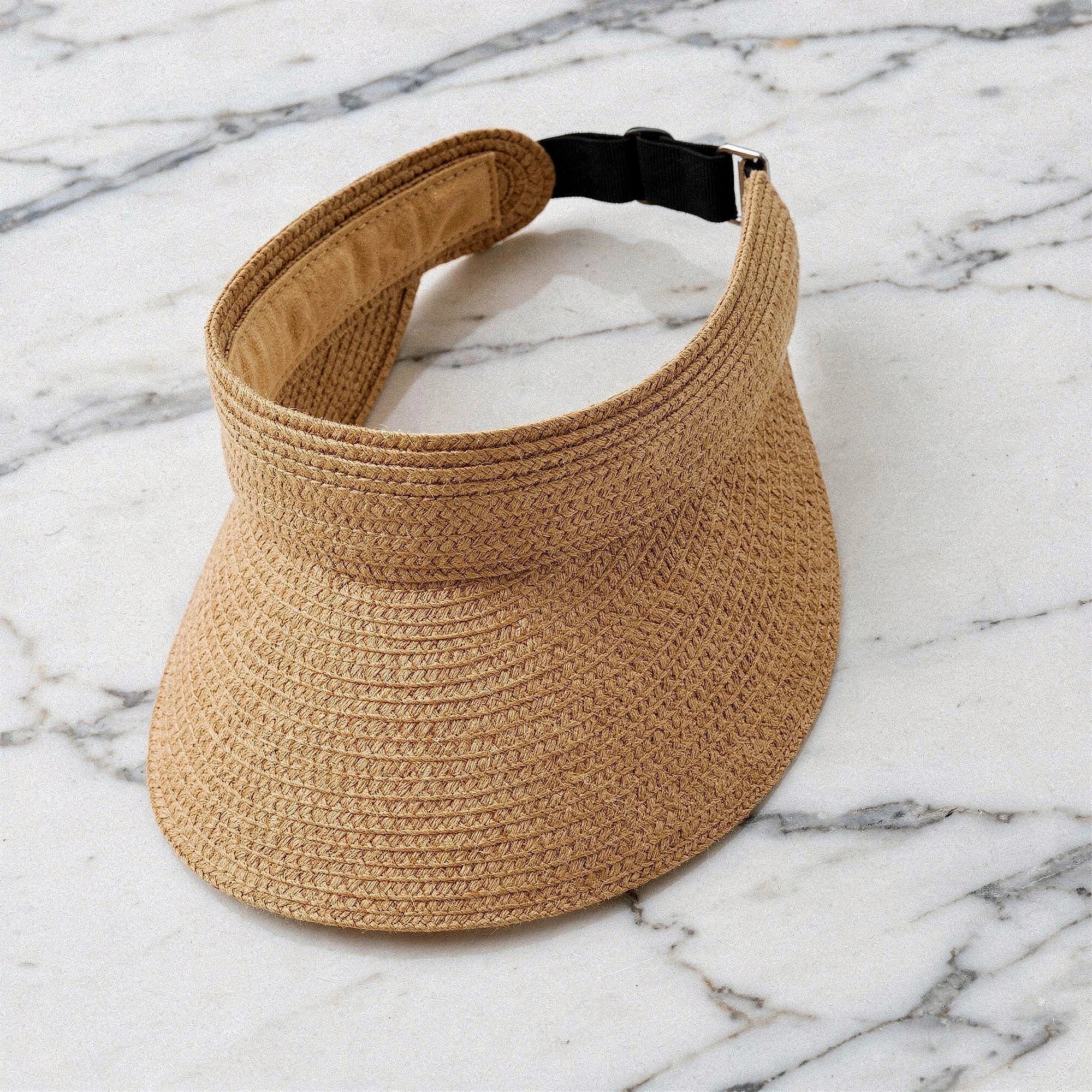View of a chic summer visor hat in light beige, featuring a wide brim and breathable woven material