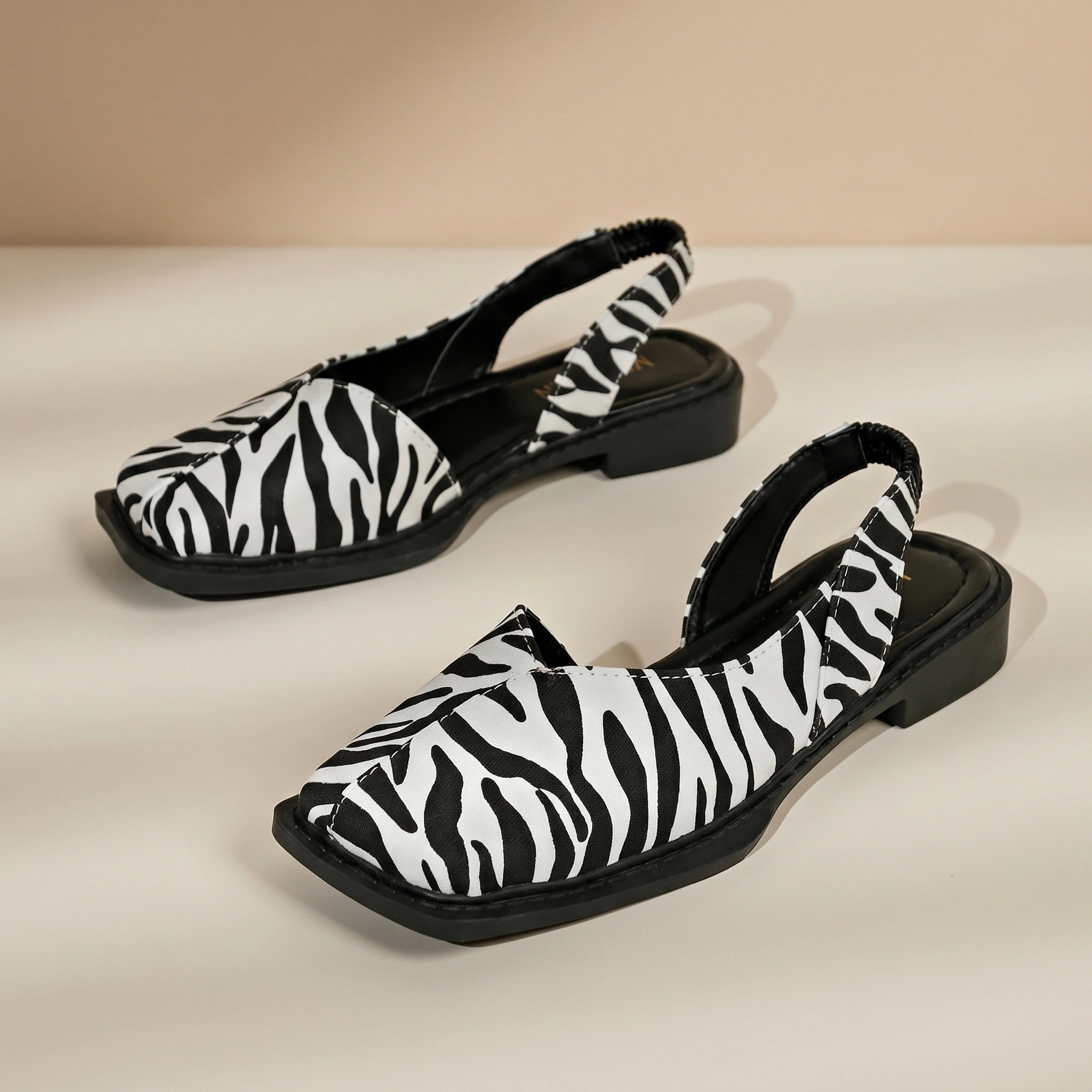 Back view of a model wearing Womens Retro Flat Sandals, showing the construction details against a soft, neutral background.