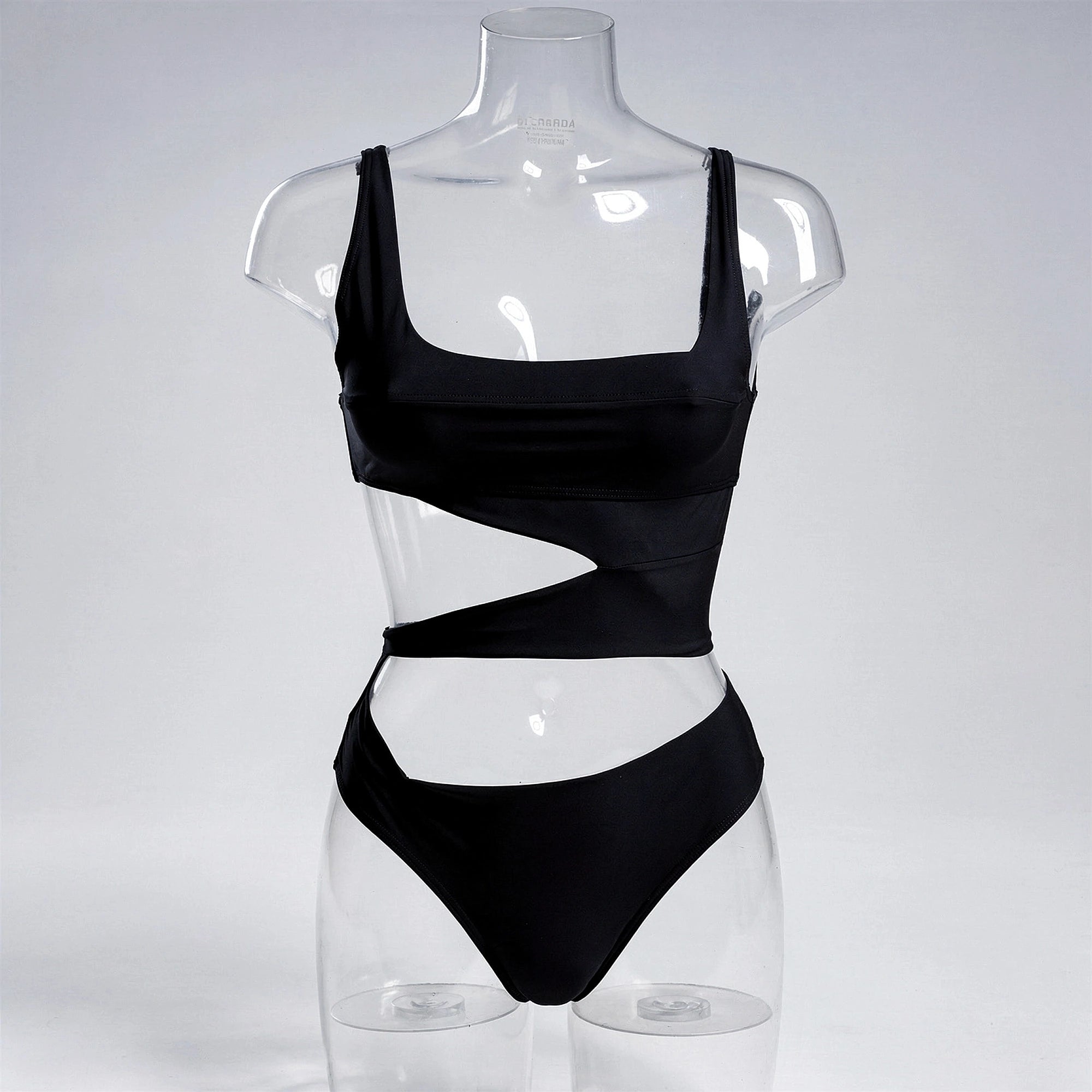 View of a black one piece swimsuit featuring a plunging neckline and cut out details, made from smooth, stretchy fabric