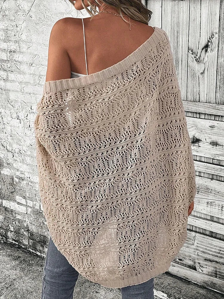 Model wearing Khaki boho delicate summer cardigan over a white top and jeans in front of a rustic wooden wall.