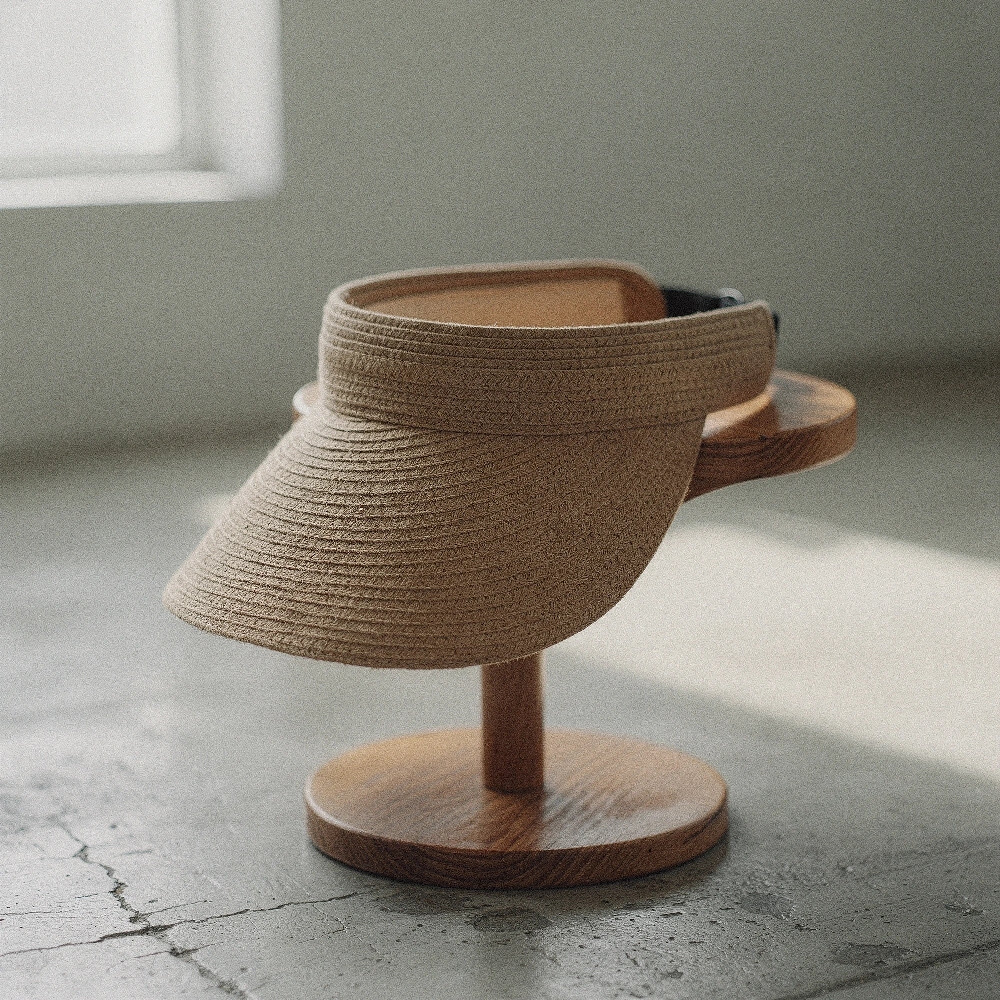 Light tan summer visor hat made of woven straw, featuring a wide brim and decorative bow , view