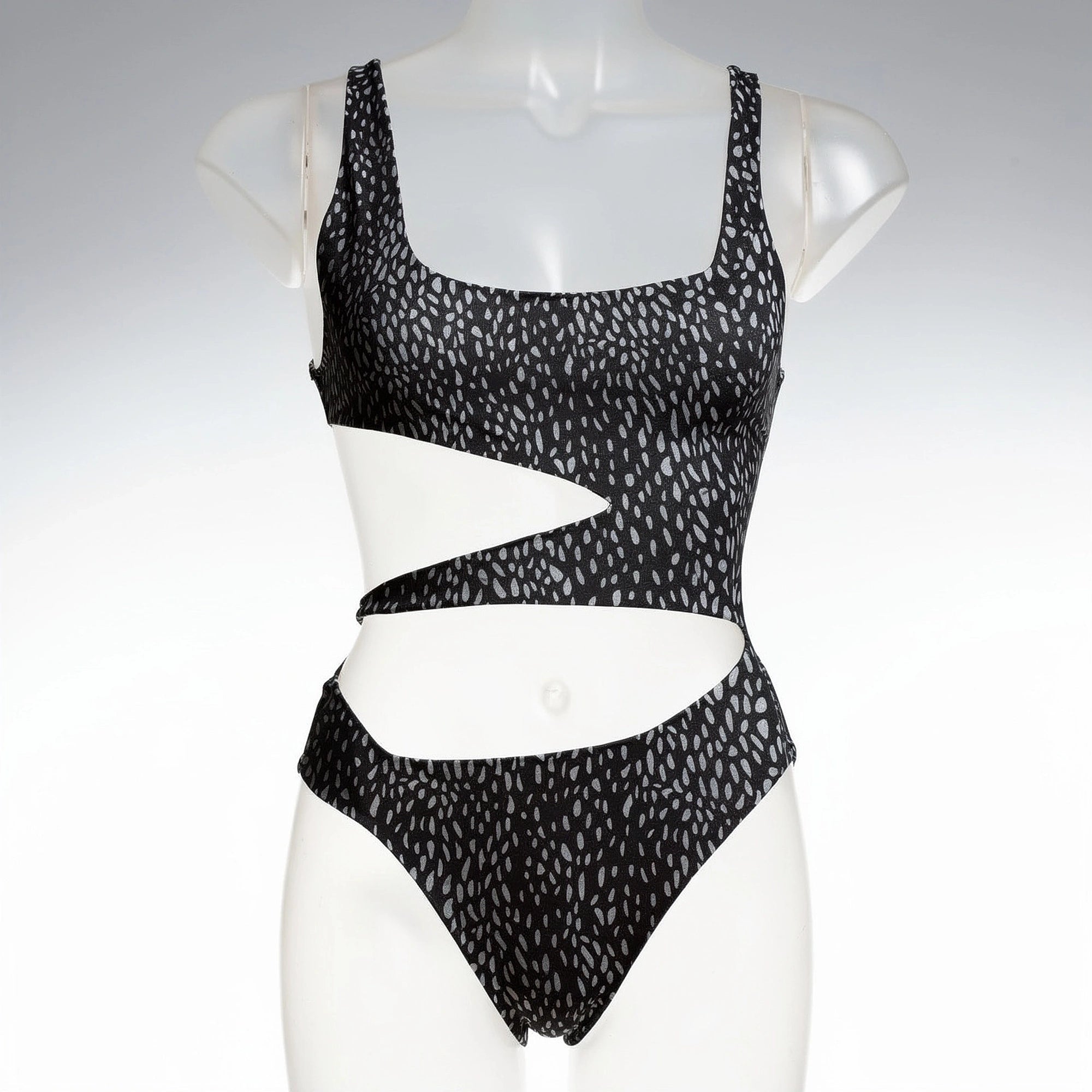 View of a black one piece swimsuit featuring a plunging neckline and cut out sides, made