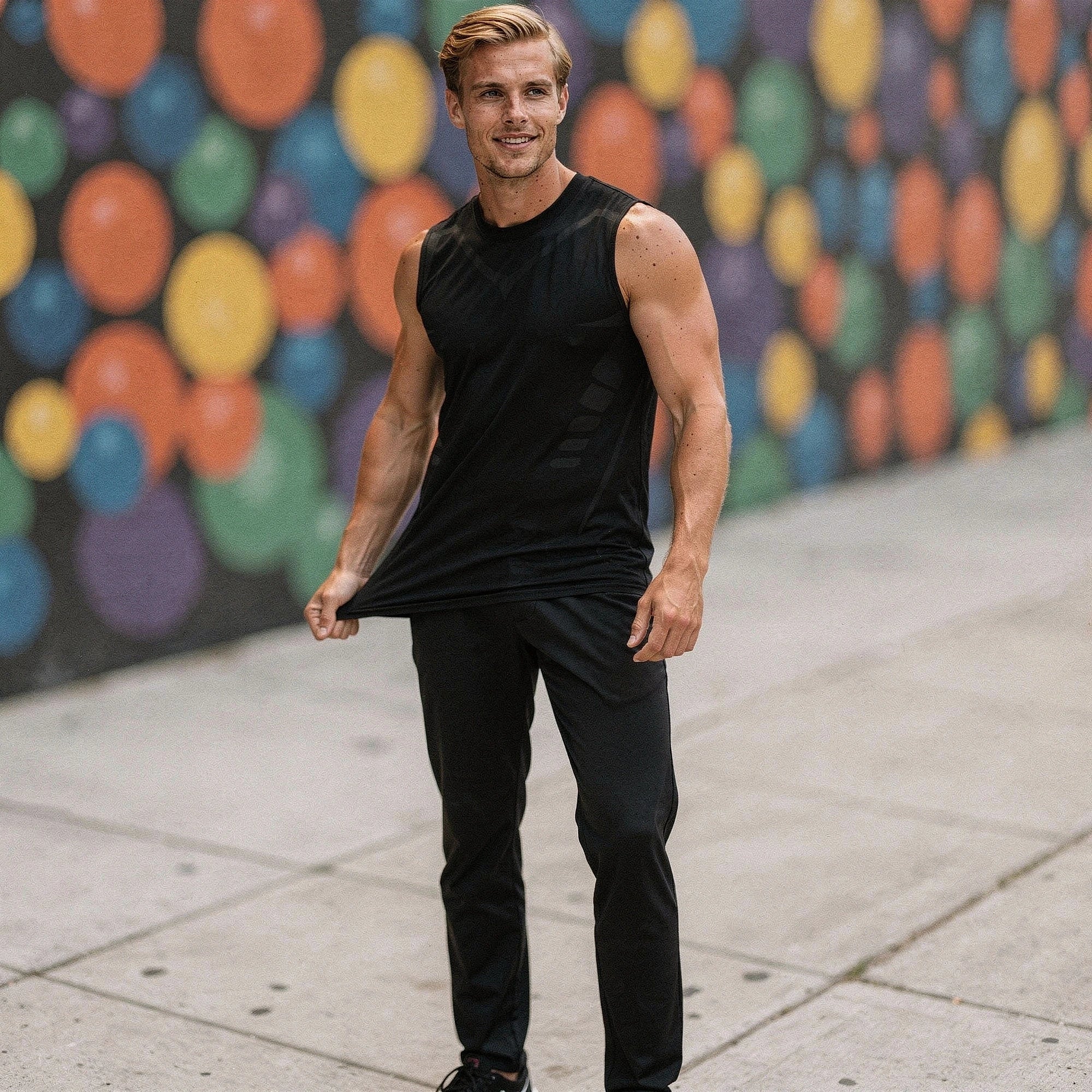 View of a sleek athletic tank in dark gray fabric, featuring quick dry material and a minimalist design