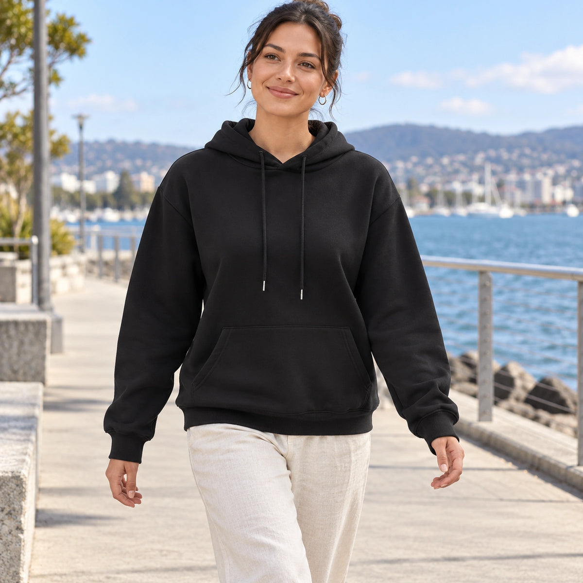 Black Lilac pullover hoodie, young model on a mild Tasmanian waterfront walk — view 8