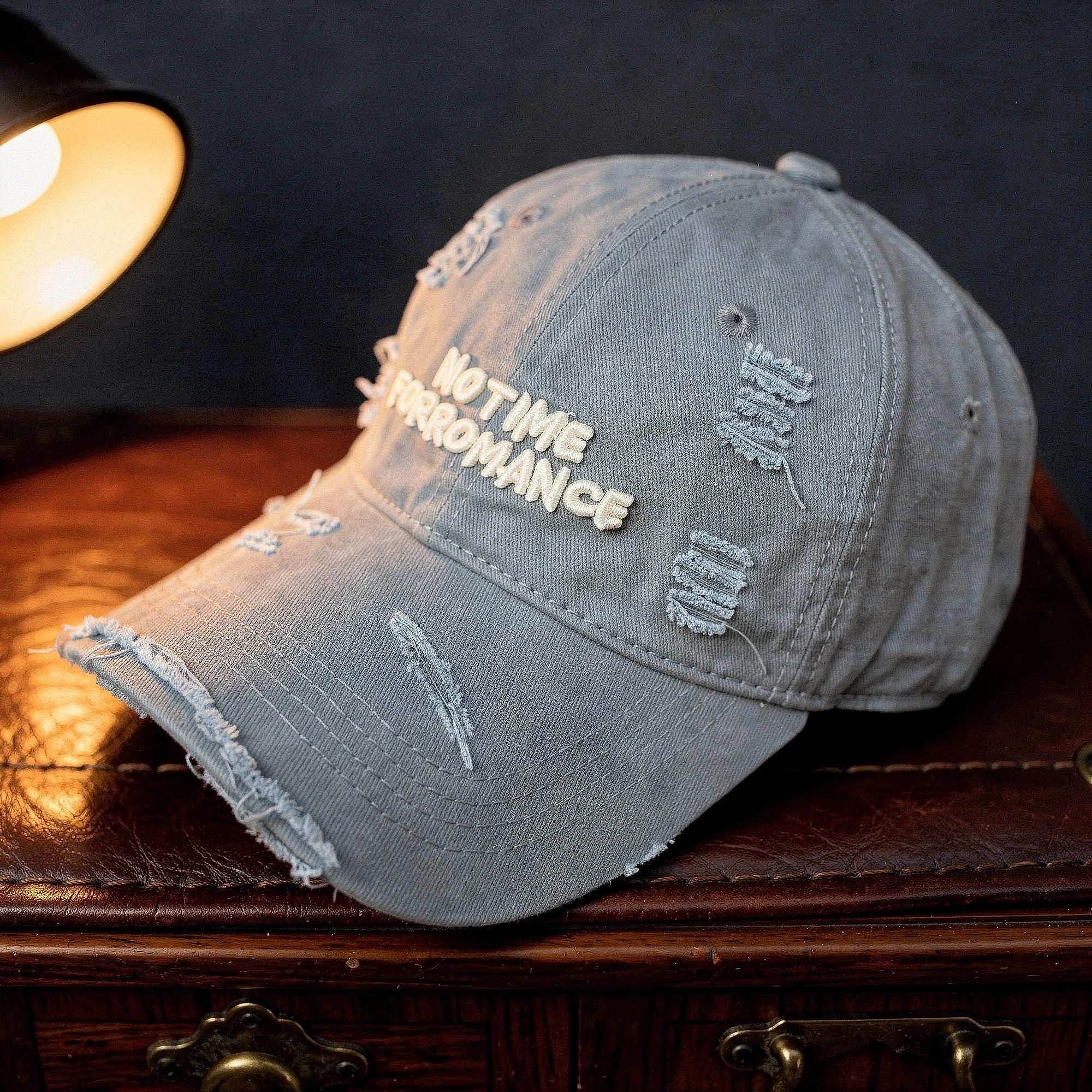 Light gray distressed baseball cap made of cotton, featuring a curved brim and adjustable strap, detailed view