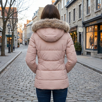 Full front view of a model showing a women's fitted winter puffer jacket in navy, paired with high waisted jeans against a cozy indoor background.