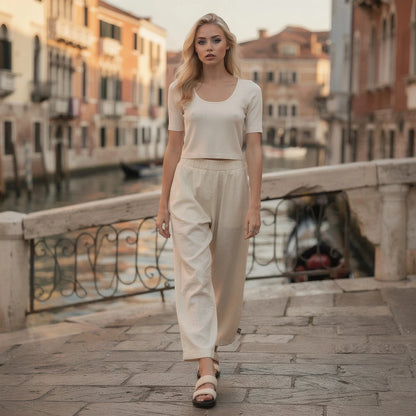 View of high waisted wide leg pants in soft fabric, featuring a smooth waistband and elegant drape in a neutral color
