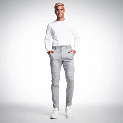 View of tailored tapered trousers in charcoal gray fabric, featuring a smooth finish and subtle pleats