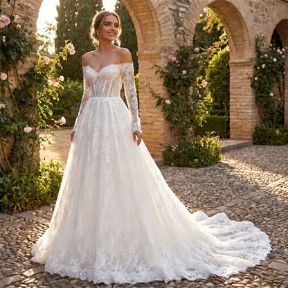 Back view of a model wearing a women's timeless wedding dress showing intricate lace detailing and a flowing silhouette against a soft, neutral background.
