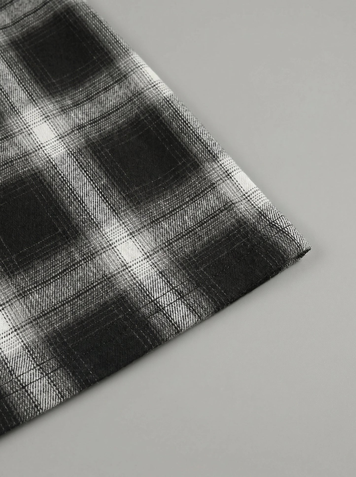 Model showing a high waisted women's plaid autumn midi skirt in warm tones, styled with a cozy sweater against a soft neutral background.