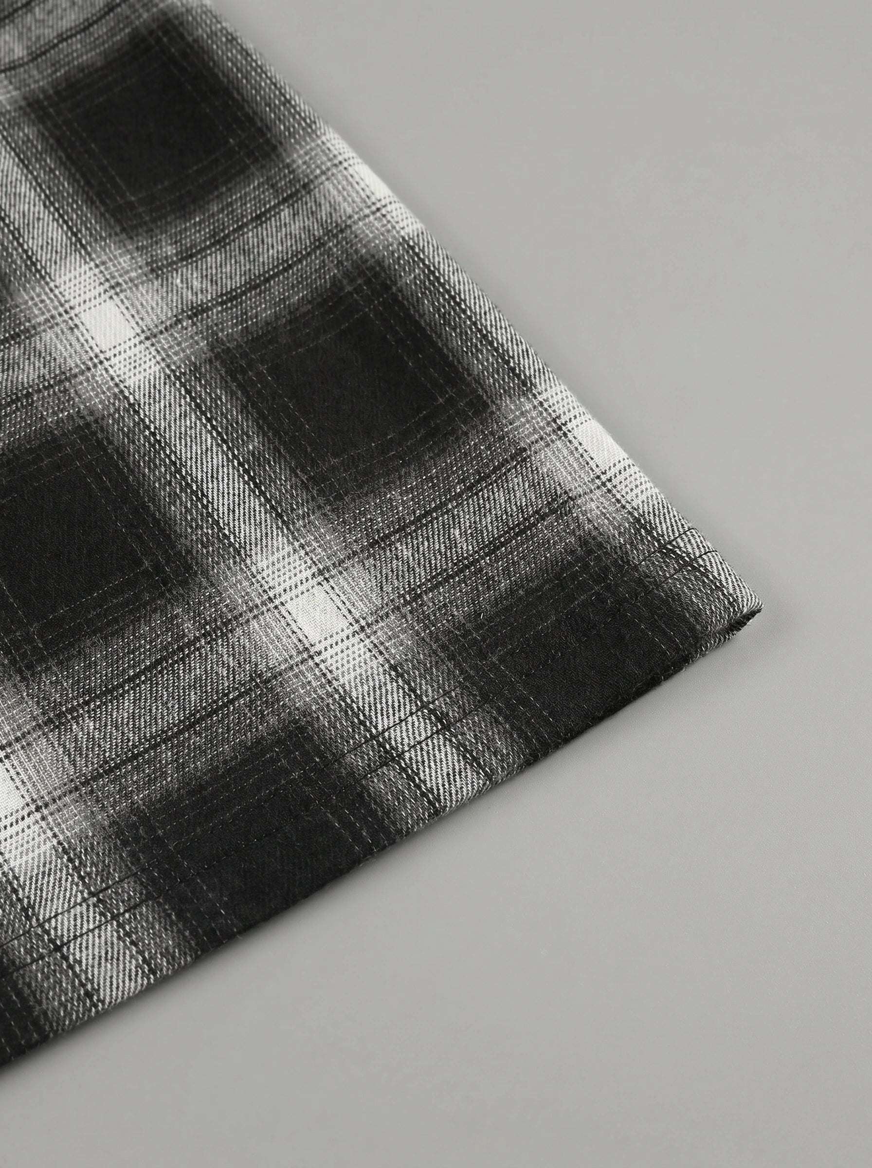 Model showing a high waisted women's plaid autumn midi skirt in warm tones, styled with a cozy sweater against a soft neutral background.