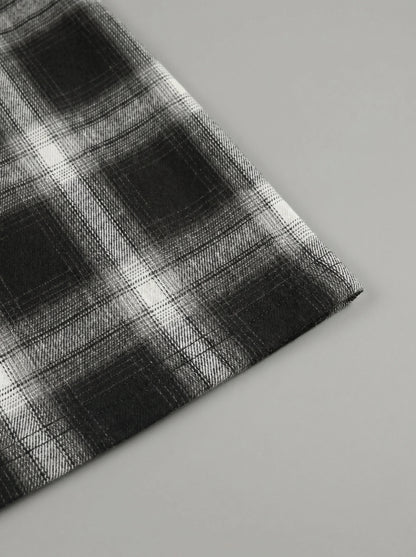 Model showing a high waisted women's plaid autumn midi skirt in warm tones, styled with a cozy sweater against a soft neutral background.