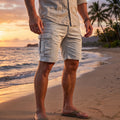 Close up view of the men's structured functional summer cargo shorts showing detailed stitching and breathable fabric in a neutral color against a light background.