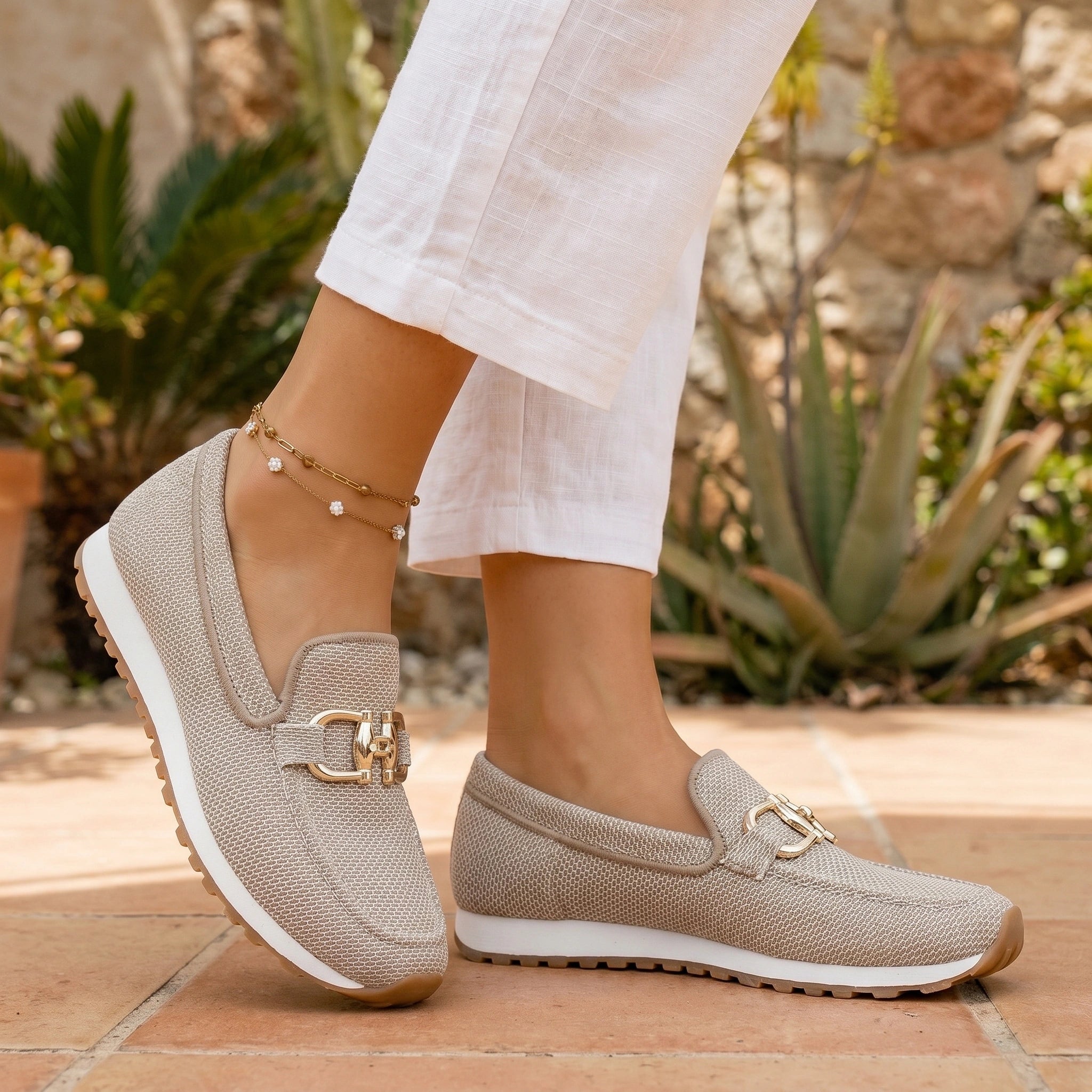 A model showcases the Womens Breathable Summer Orthopedic Loafers in a outfit, showing a light pastel color palette against a bright, minimalistic background.