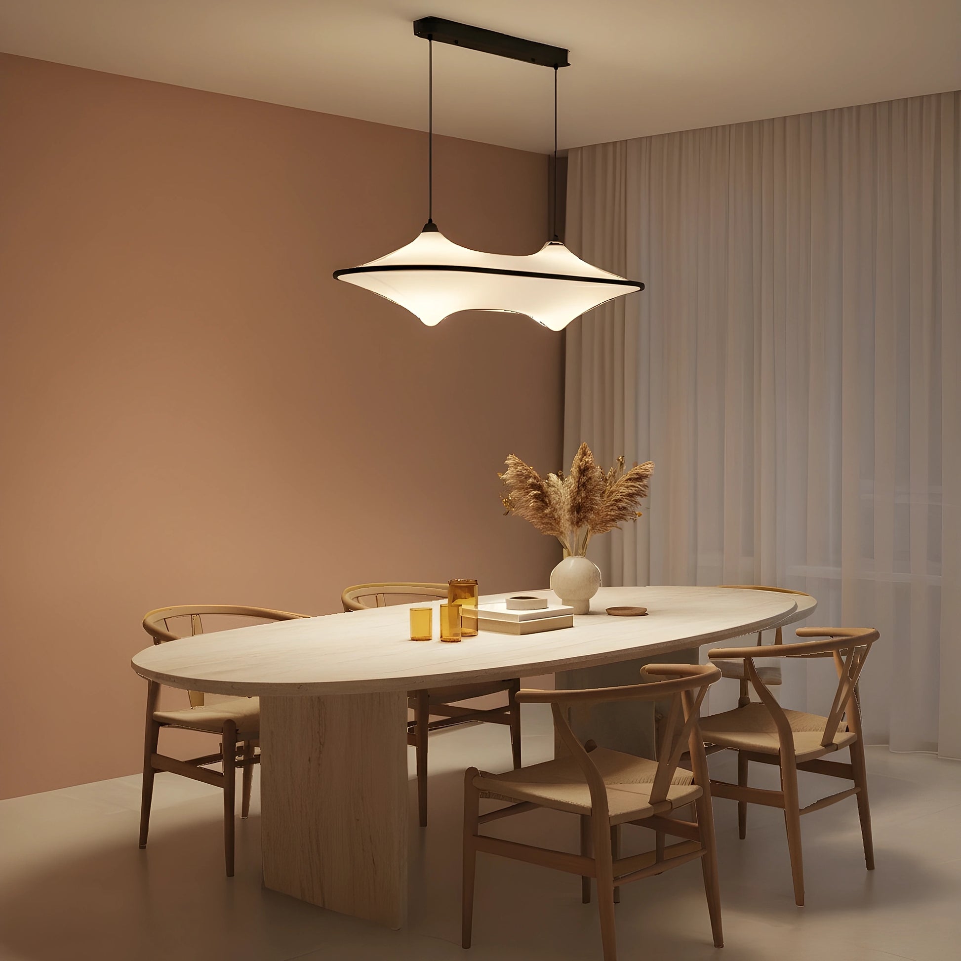 Close up of the sleek modern iron pendant light fixture showing its minimalist design, fluid silhouette, and intricate detailing against a soft, white background.