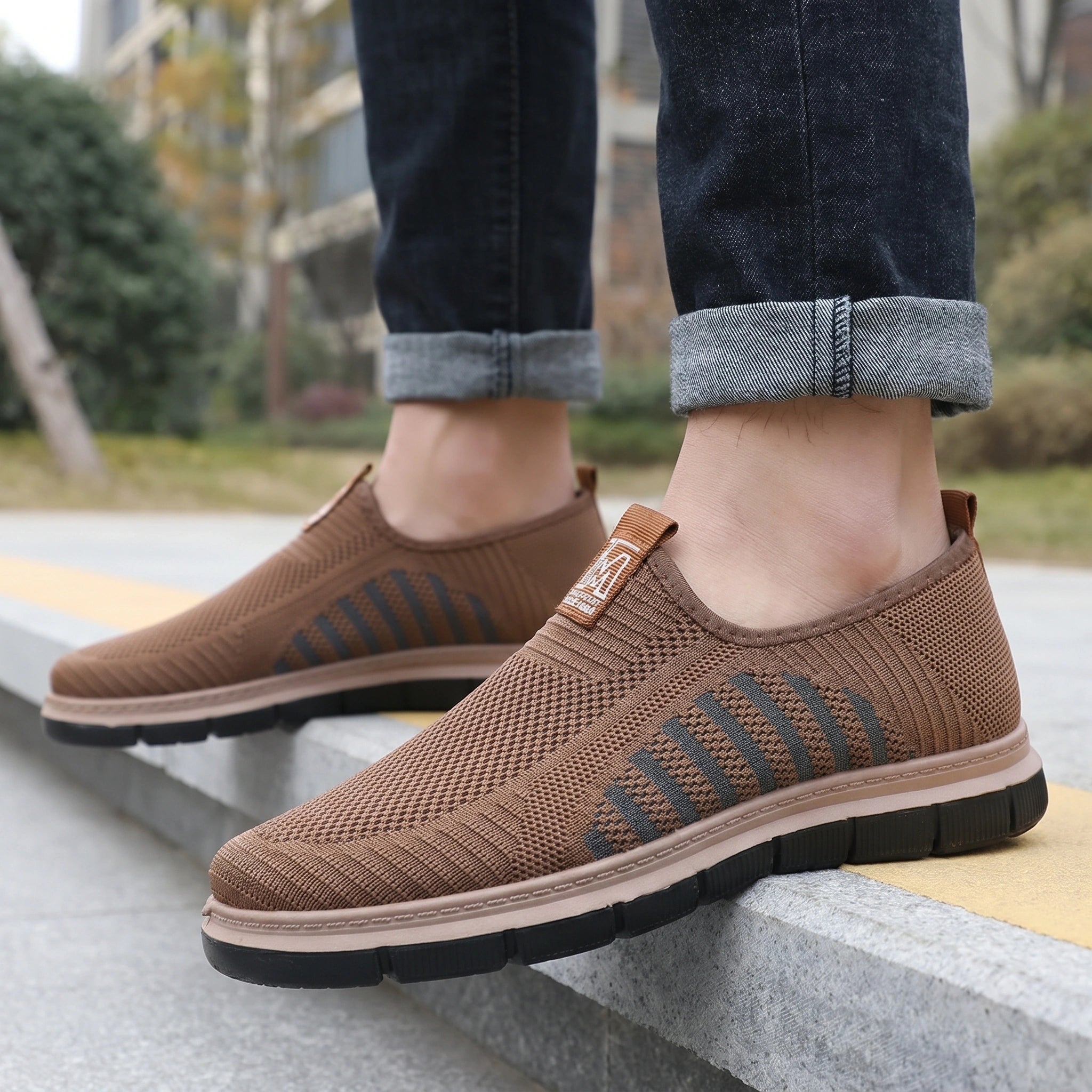 Close up view of the knit upper of men's casual shoes, showing intricate stitching and texture against a neutral background.