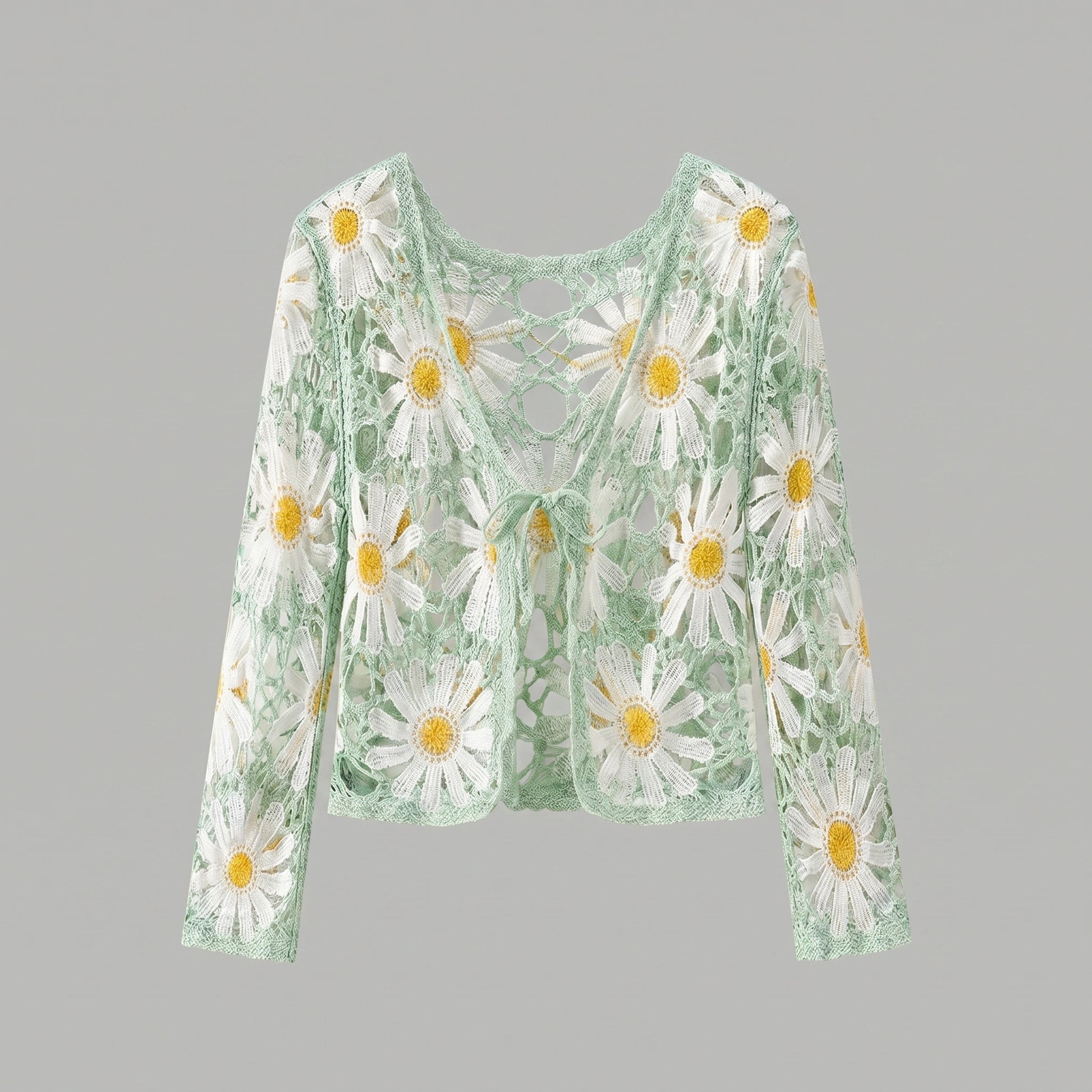 A model showcases a lightweight sheer boho summer cardigan in Light Green, styled with high waisted shorts against a bright beach backdrop.