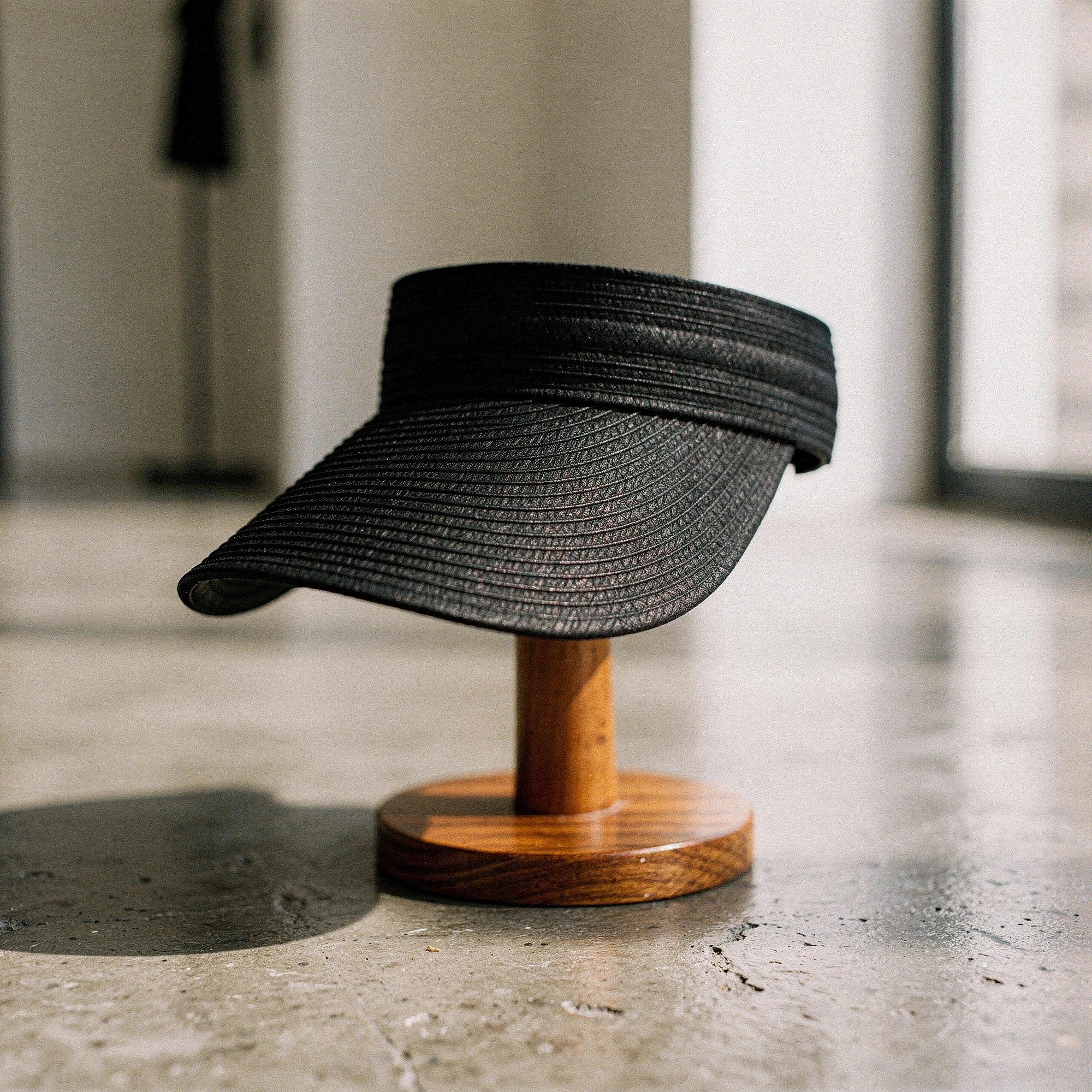 Light beige summer visor hat made of straw, featuring a wide brim and a decorative ribbon band, view