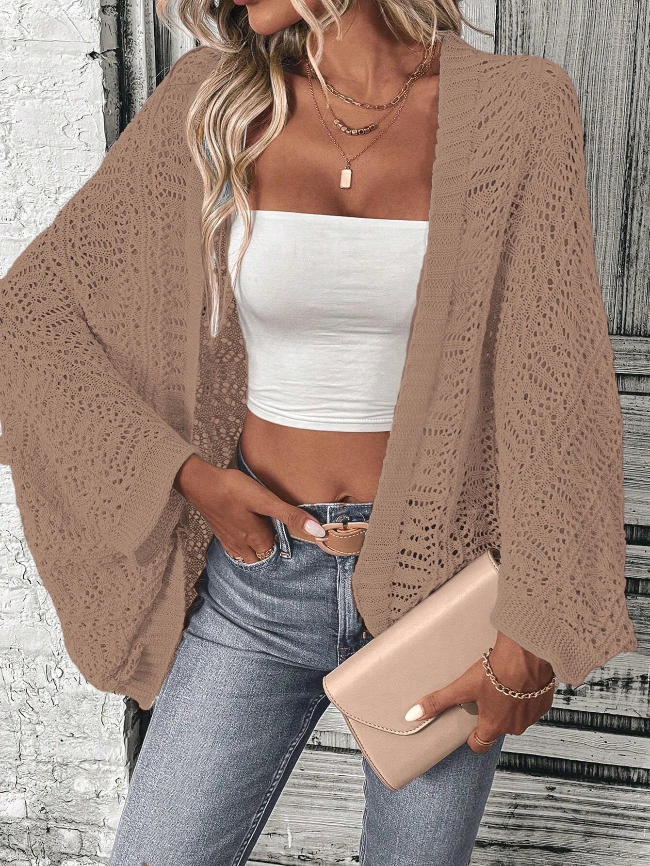 Model wearing Khaki boho delicate summer cardigan over a white tube top with jeans, holding a clutch in an outdoor setting.