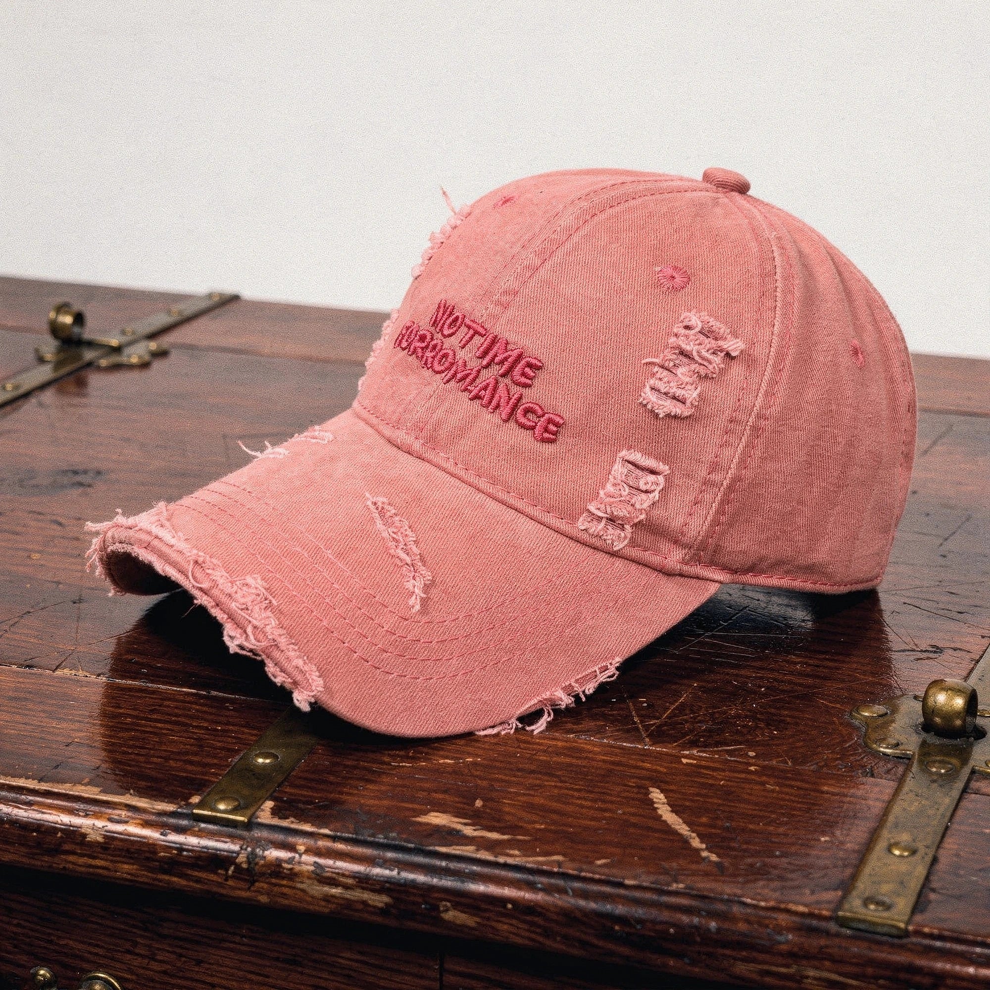 View of a chic distressed baseball cap in light blue denim, featuring a curved brim and adjustable strap