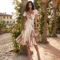 A model showcases a vibrant floral print V neck A line dress with ruffle waist details against a soft pastel background, perfect for spring and summer events.