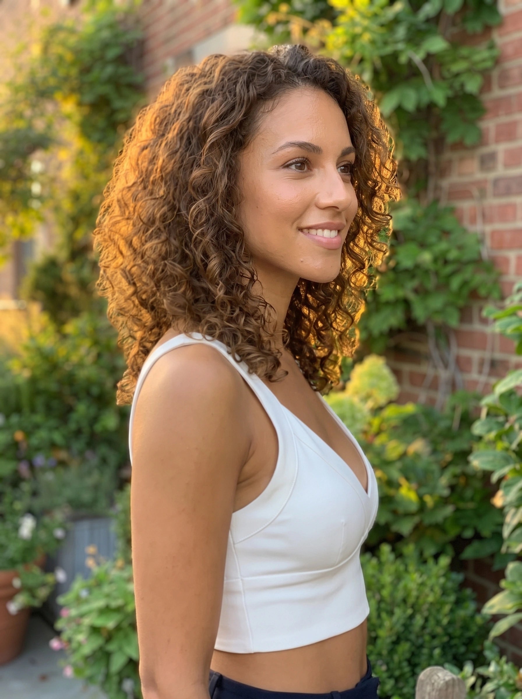 A model showcases the Womens Supportive Cropped Top in a soft pastel color, paired with high waisted jeans against a minimalist backdrop.