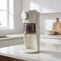 View of a compact electric ice shaver with a sleek design, featuring a clear ice chamber and easy to use controls