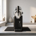 Sleek countertop slush machine with a clear bowl, digital control panel, and vibrant slush creations on display