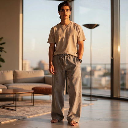 View of relaxed wide leg trousers in soft beige fabric, featuring a comfortable waistband and pockets