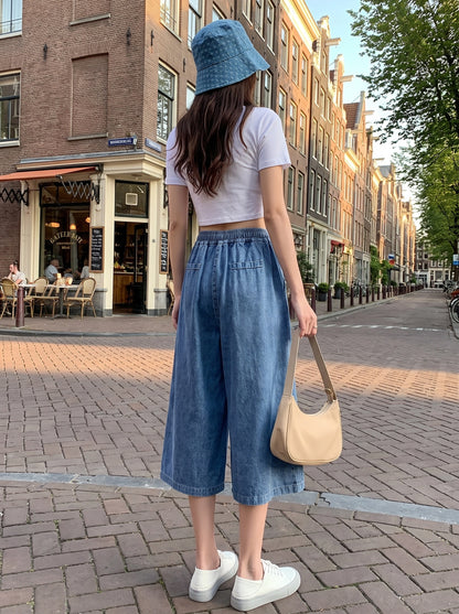 Back view of a model showing the Womens Flared Autumn Skirt Pants in a rich denim hue, showing its construction and design.