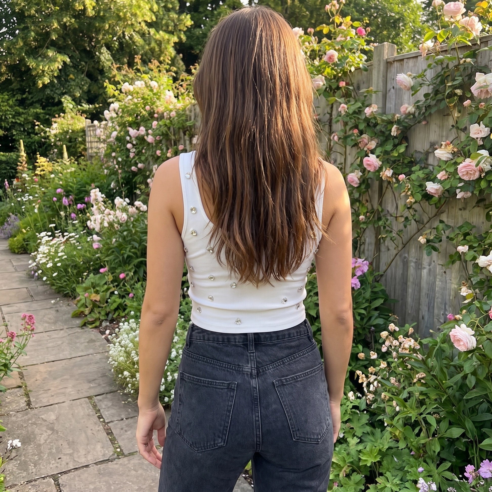 Back view of a model wearing a women's figure hugging crop top in a colorful, showing its construction and flattering fit against a neutral background.