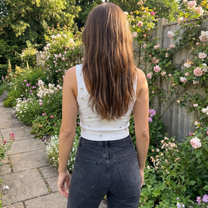 Back view of a model wearing a women's figure hugging crop top in a colorful, showing its construction and flattering fit against a neutral background.