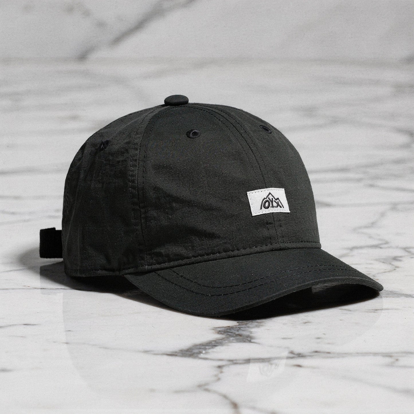 View of a stylish men's baseball cap in dark gray, made from breathable fabric, featuring a curved brim and adjustable strap