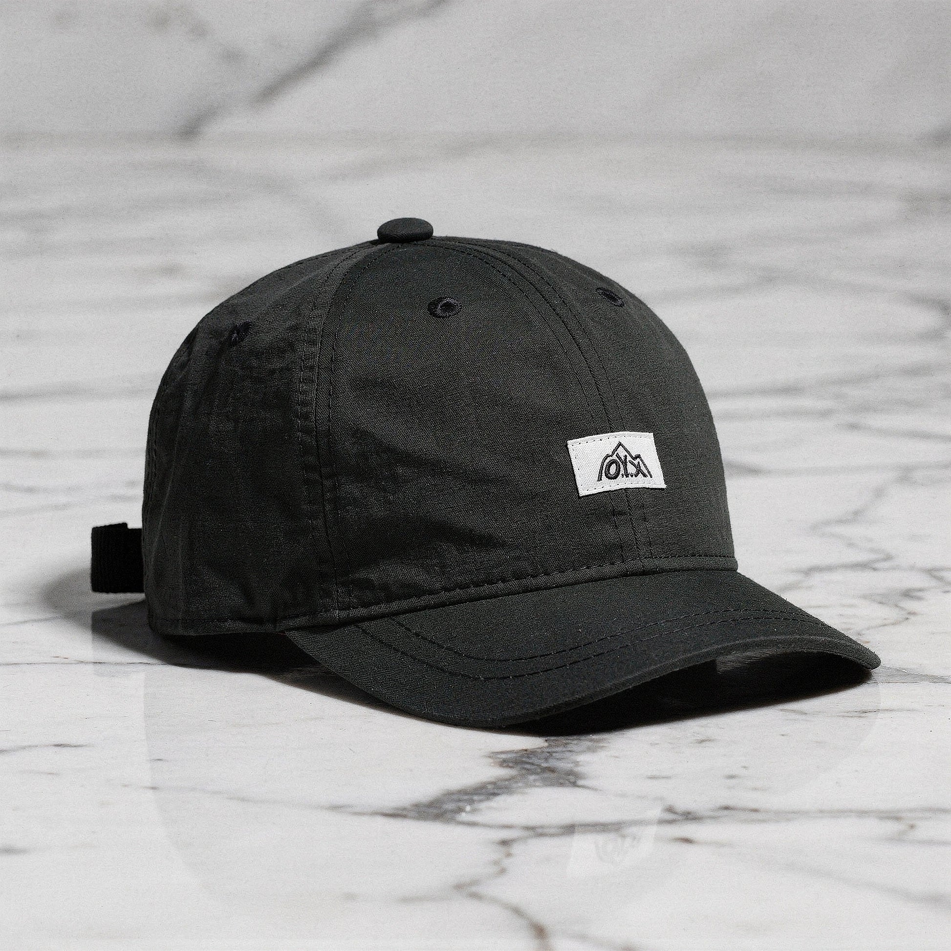 View of a stylish men's baseball cap in dark gray, made from breathable fabric, featuring a curved brim and adjustable strap