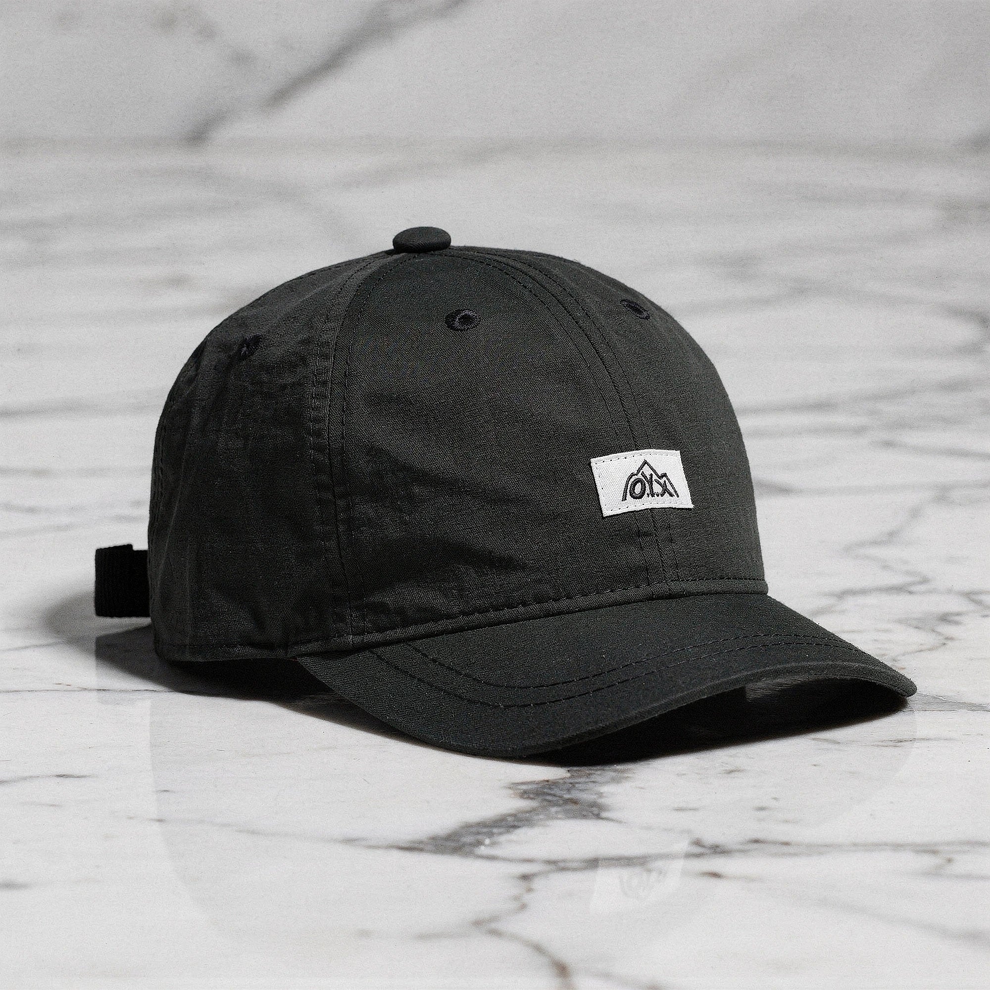 View of a stylish men's baseball cap in dark gray, made from breathable fabric, featuring a curved brim and adjustable strap