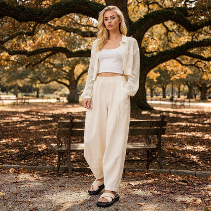 View of elegant high waisted wide leg pants in soft beige fabric, showcasing the flowing silhouette and pleated