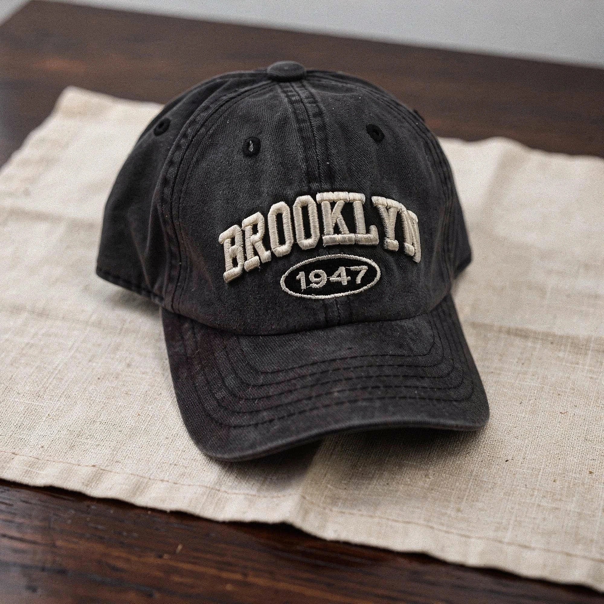 View of a navy blue cap featuring intricate white embroidery, showcasing a casual and chic design