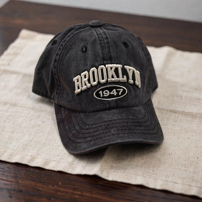 View of a navy blue cap featuring intricate white embroidery, showcasing a casual and chic design
